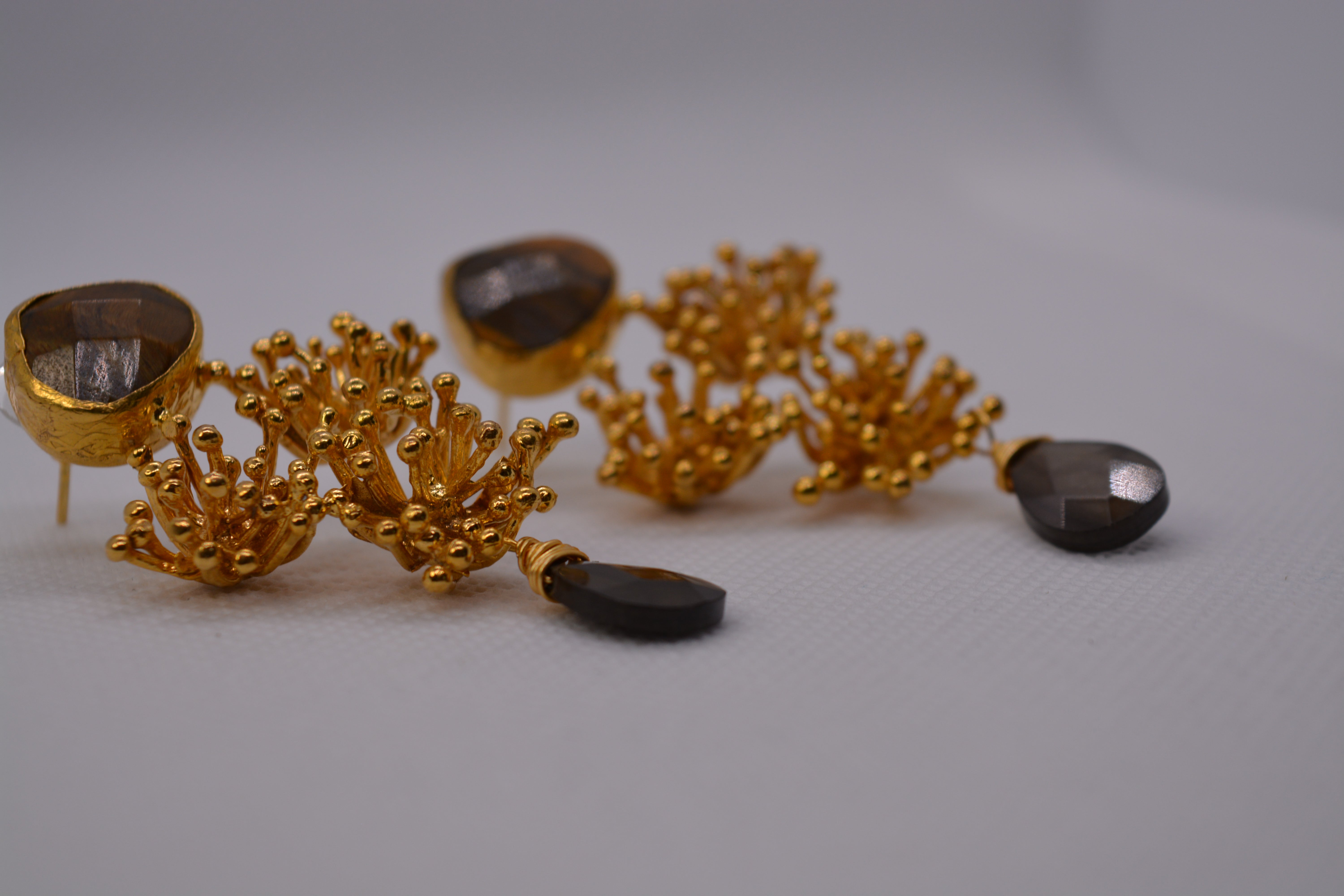 Orecchini dorati con pietra grigia e design floreale