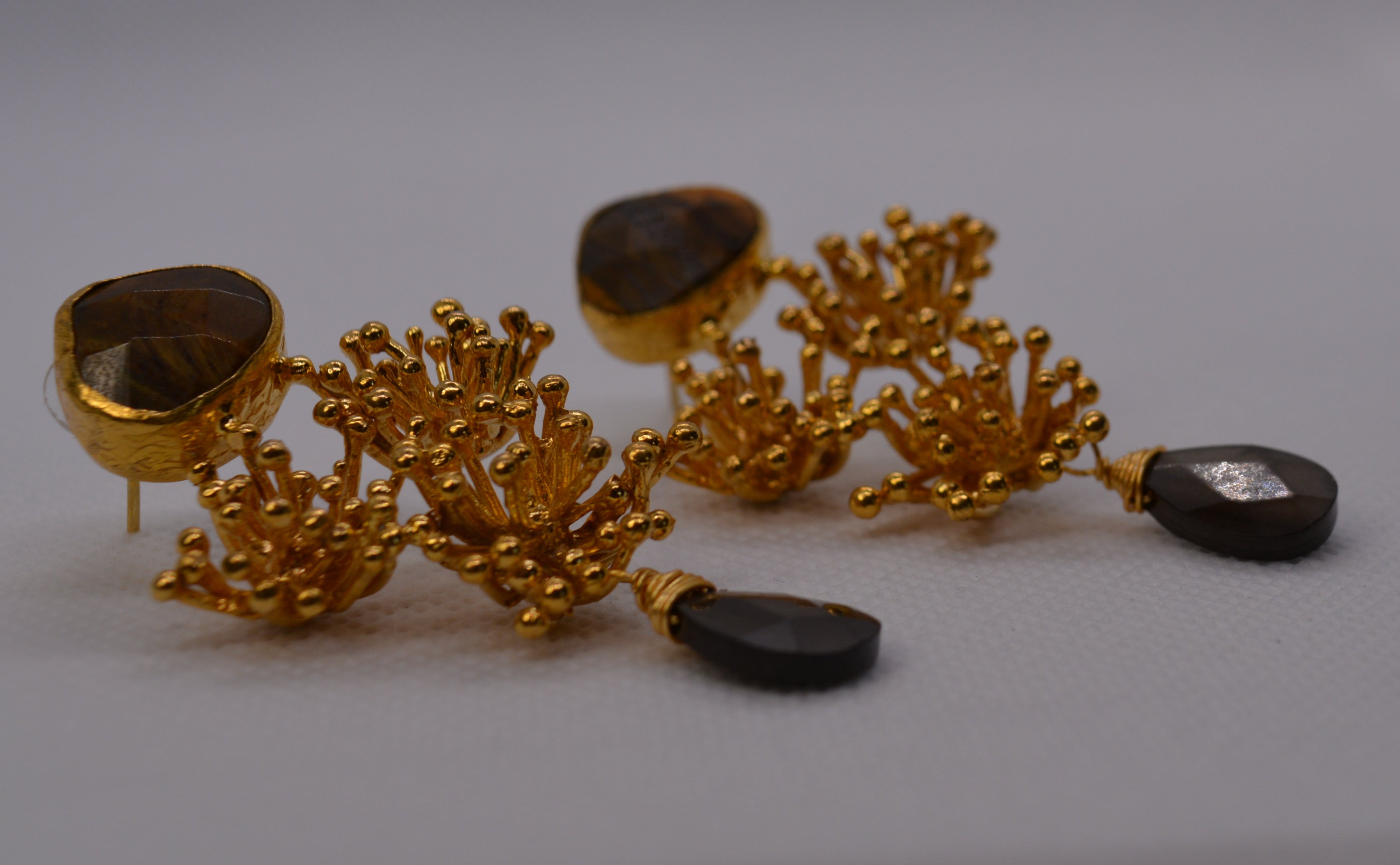 Orecchini dorati con pietra grigia e design floreale