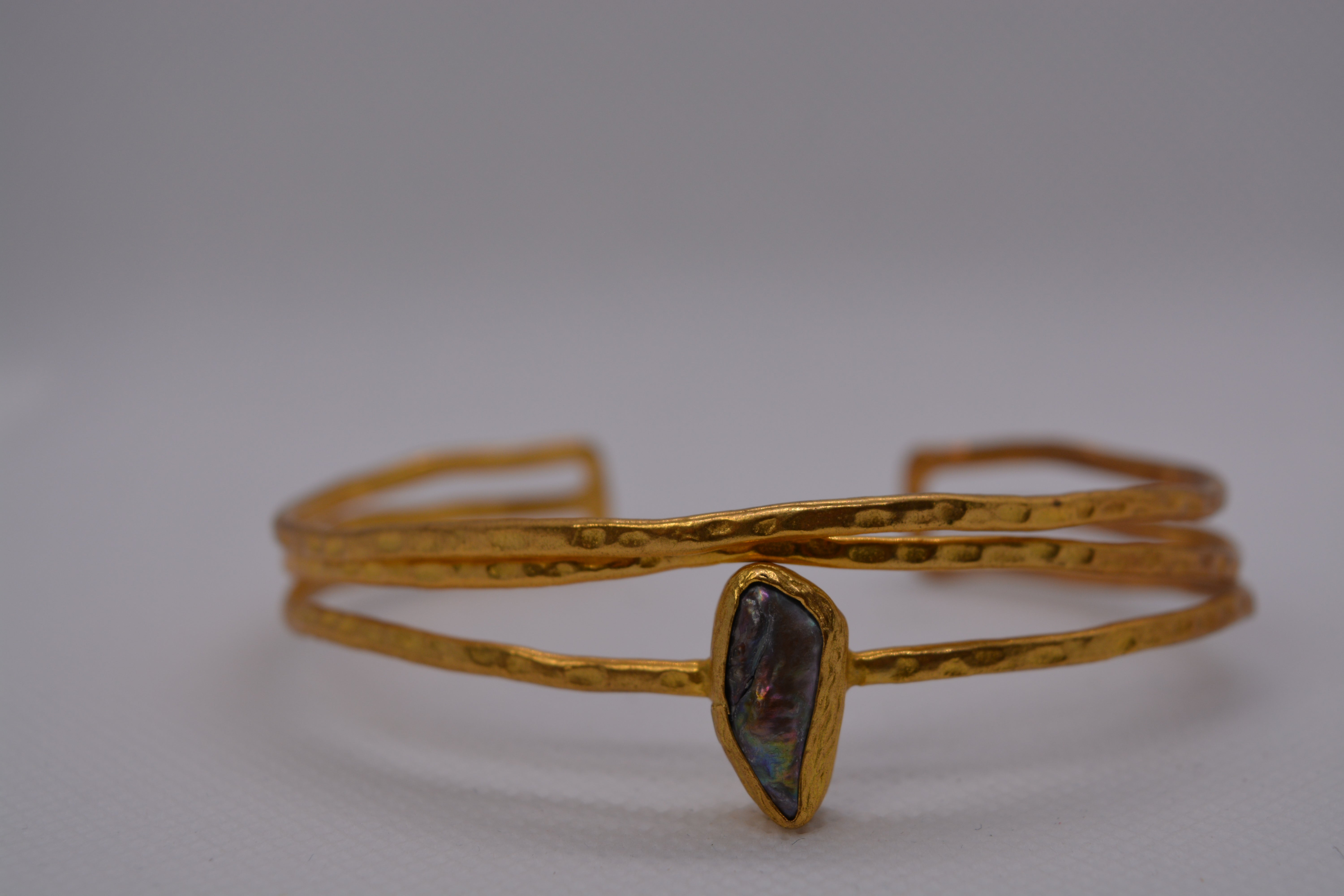 Bracciale rigido dorato con pietra naturale iridescente