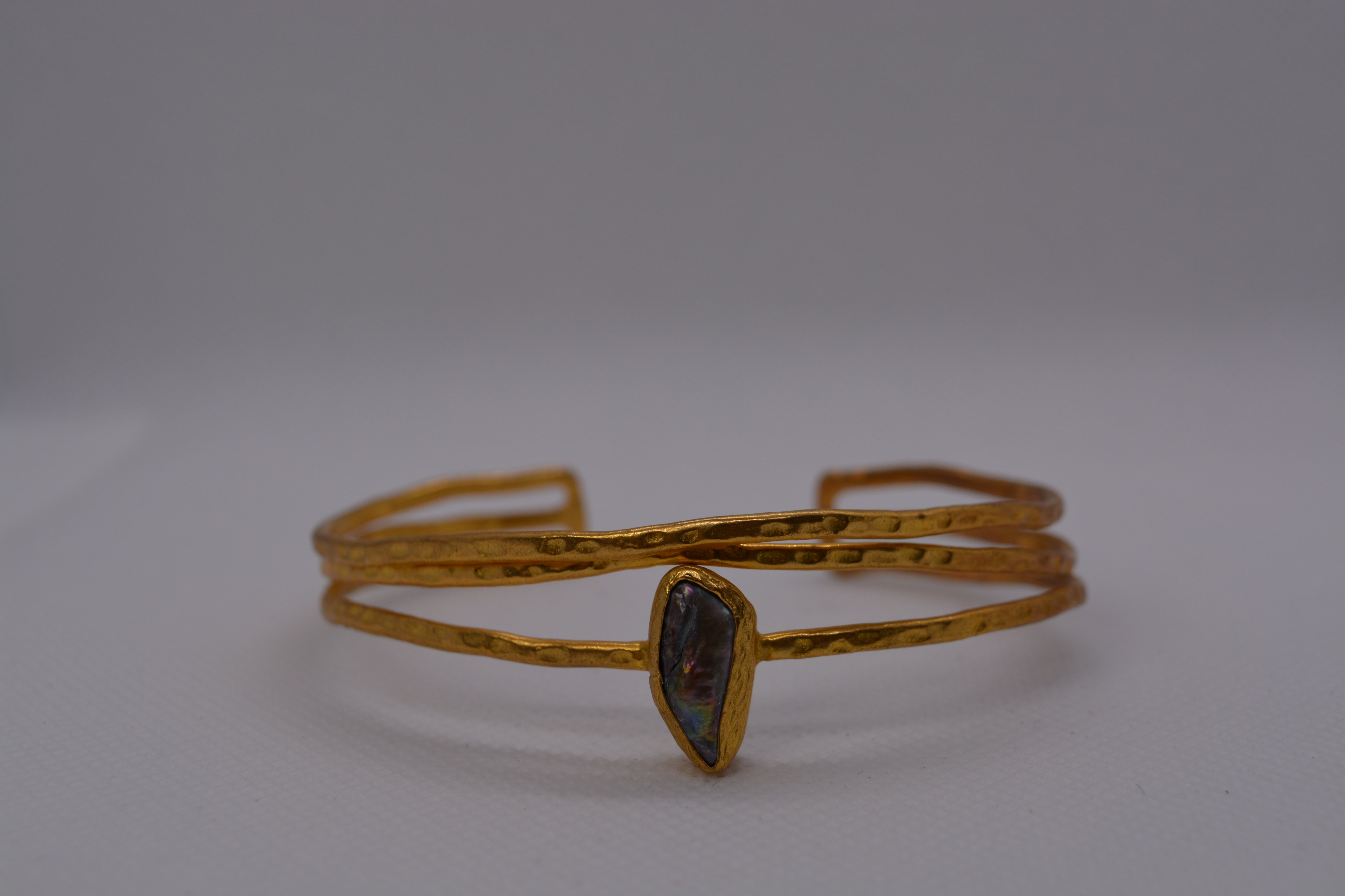 Bracciale rigido dorato con pietra naturale iridescente