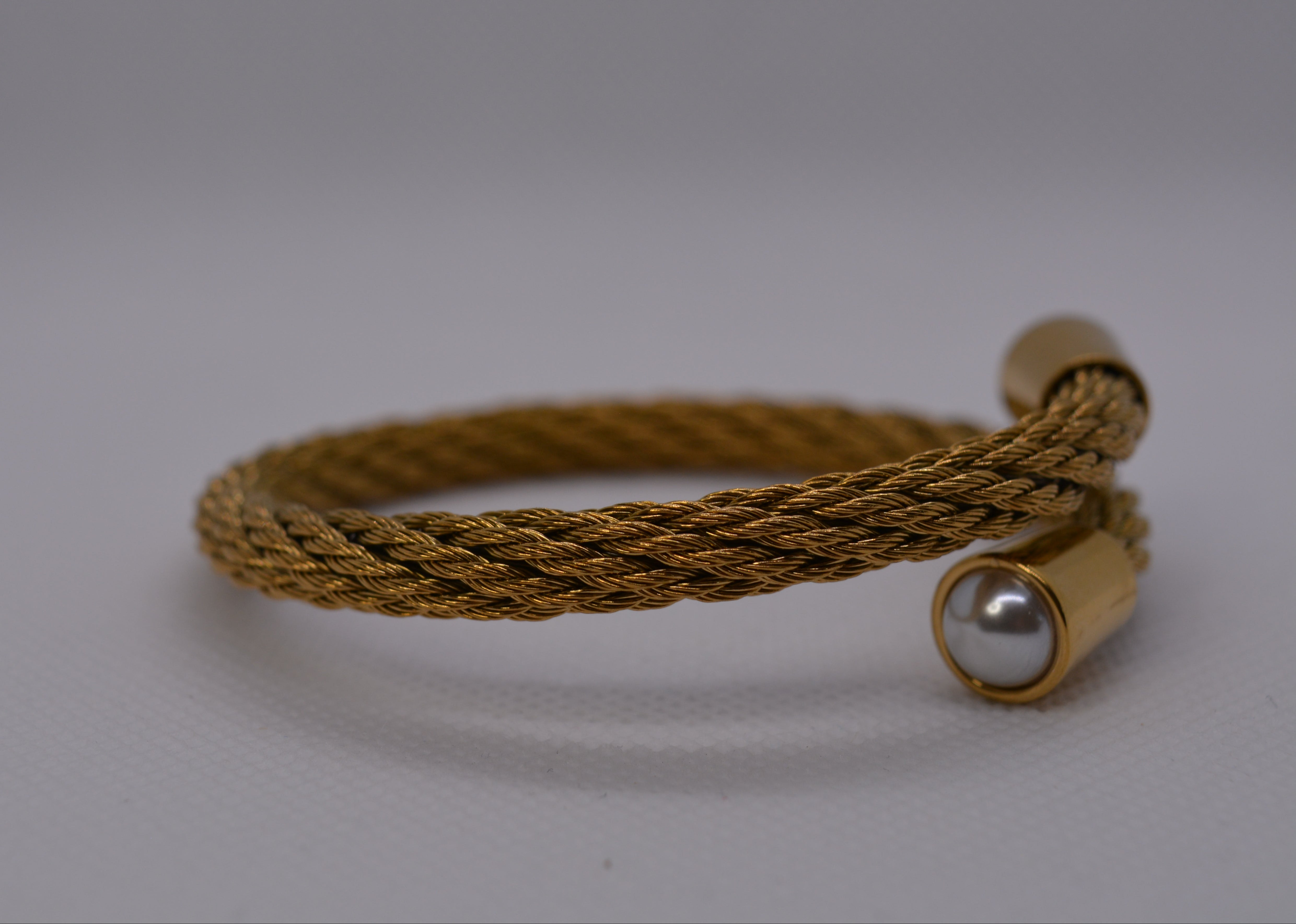 Bracciale rigido dorato con perla