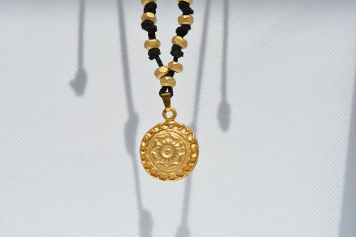 Collana nera con ciondolo dorato inciso